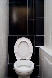 Фото: туалет с зашитыми пластиковыми панелями трубками канализации 
